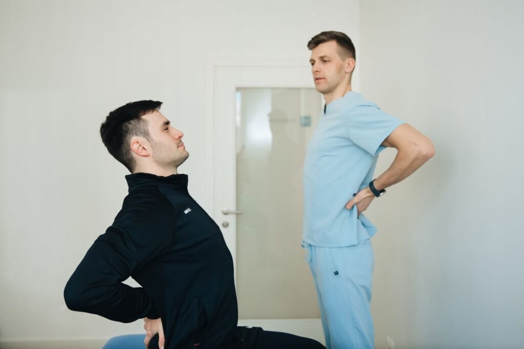 A physiotherapist instructs a patient on back exercises in a clinic setting.