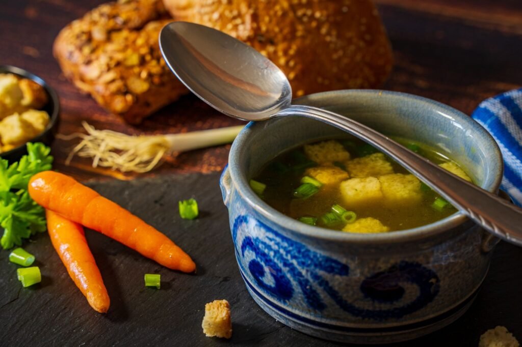 Delicious vegetable broth with croutons served in a blue bowl, perfect for a comforting winter meal.