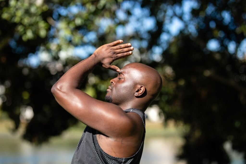 Close-up of a bald African American man meditating outdoors, embracing a healthy lifestyle.