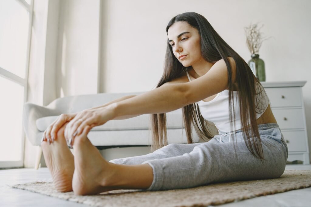 Young woman stretches on a rug in a light-filled room, embracing home fitness.