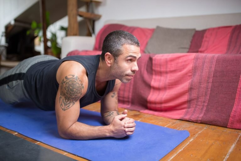 Man doing plank exercise indoors on a yoga mat, embracing a healthy lifestyle.