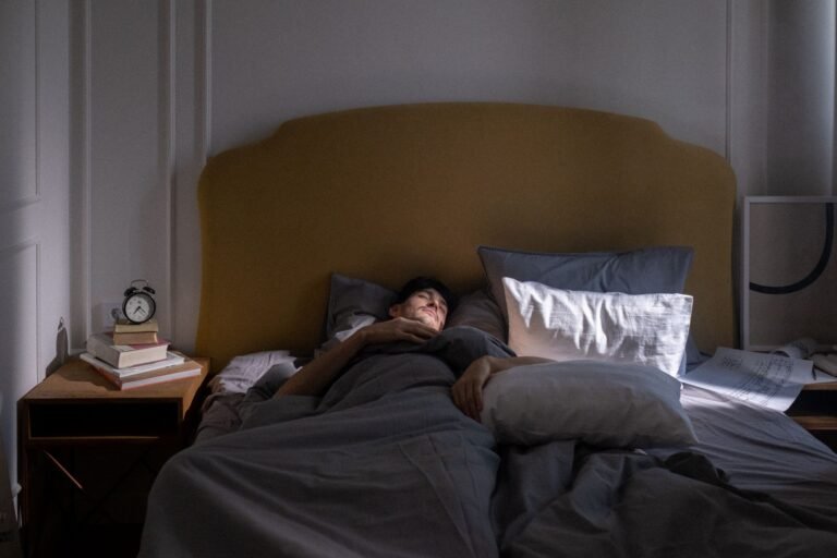 A man sleeping in a cozy bed with soft morning sunlight filtering in.