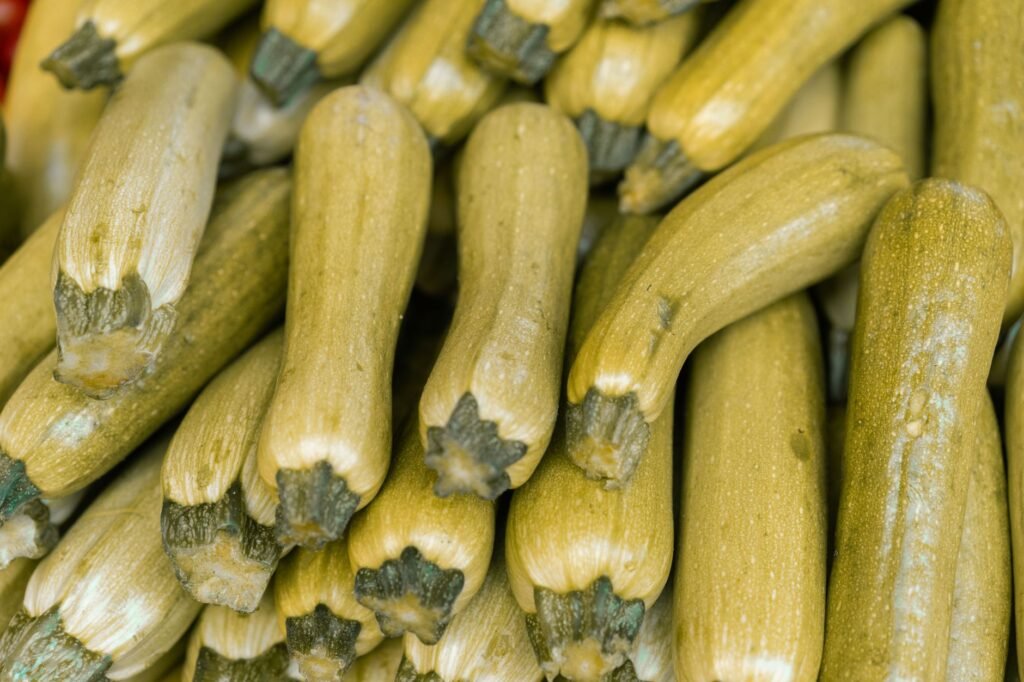 Close-up of fresh zucchinis at a market, showcasing their nutritious appeal and abundance.
