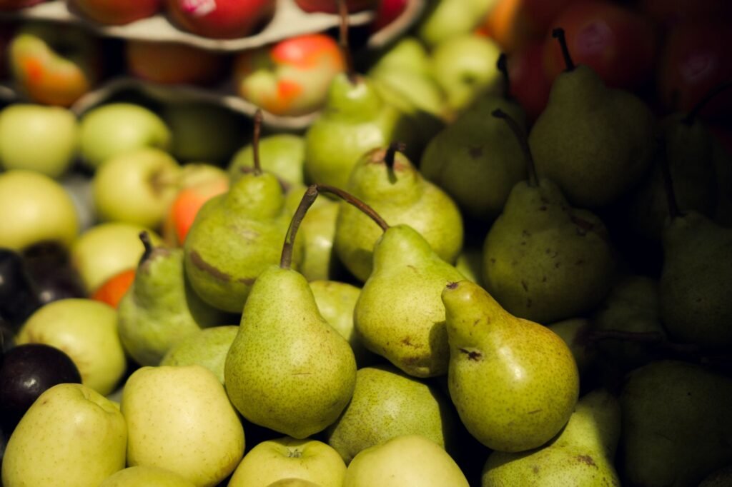 Vibrant green pears and apples displayed at a farmers' market.