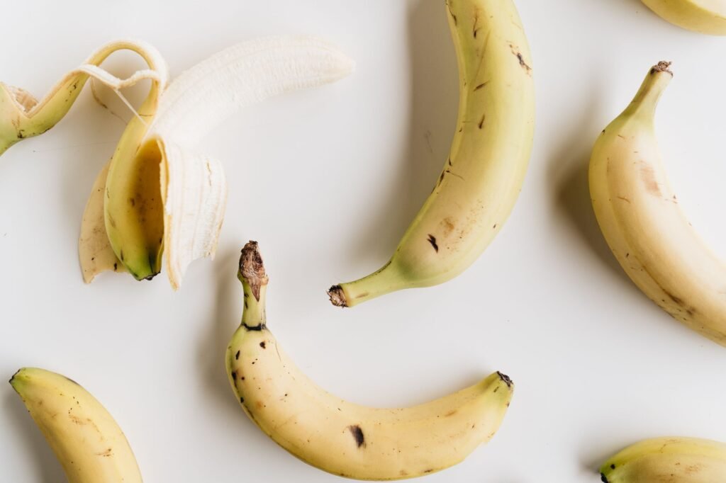 A flat lay photo of ripe bananas on a white background, showcasing healthy eating and minimalism.