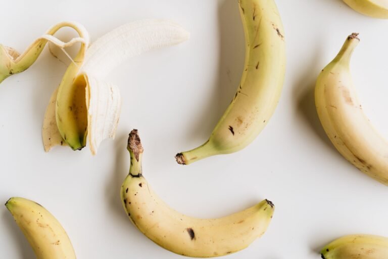 A flat lay photo of ripe bananas on a white background, showcasing healthy eating and minimalism.
