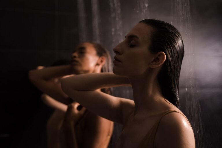 Two women enjoying a calming shower experience in a serene spa environment.