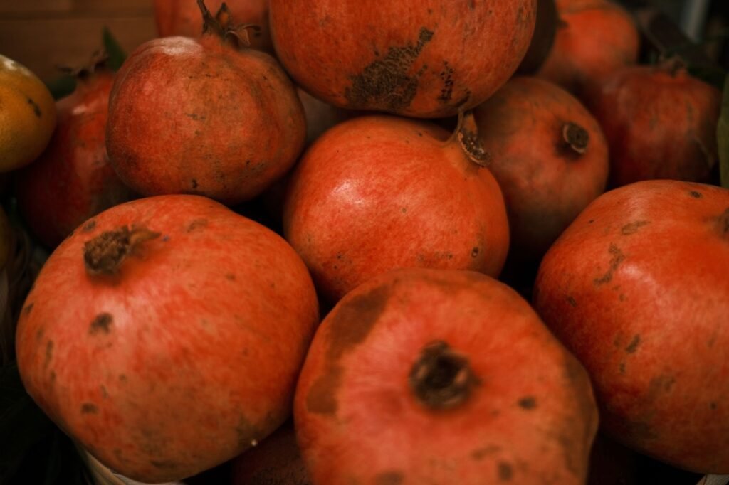 A vibrant close-up of fresh ripe pomegranates showcasing their natural texture and rich color.