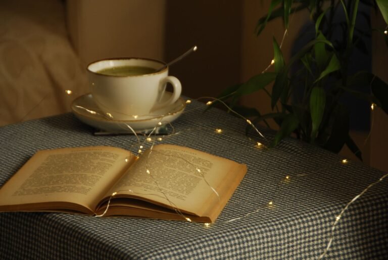 A cozy setup with an open book, coffee cup, and warm lights, perfect for relaxation.