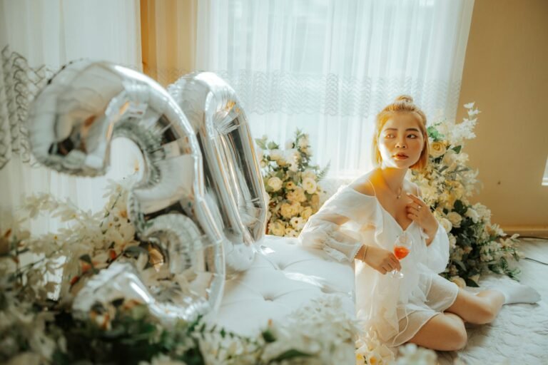 A woman celebrates her 30th birthday surrounded by flowers and balloons indoors.
