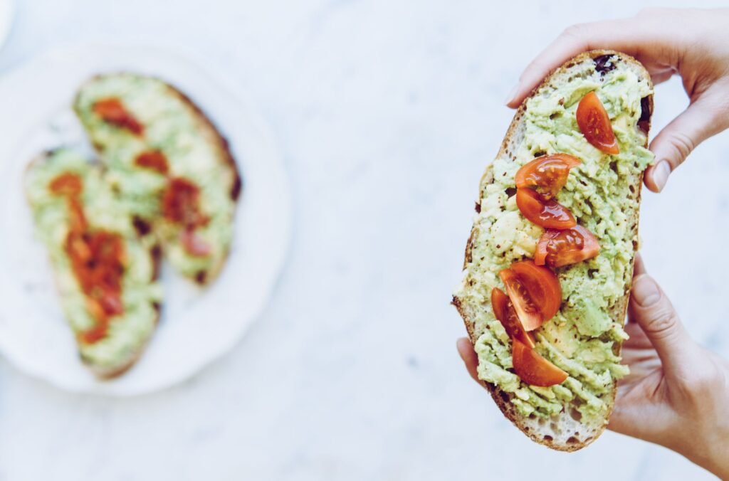Delicious avocado toast topped with cherry tomatoes, perfect for a fresh and healthy snack.