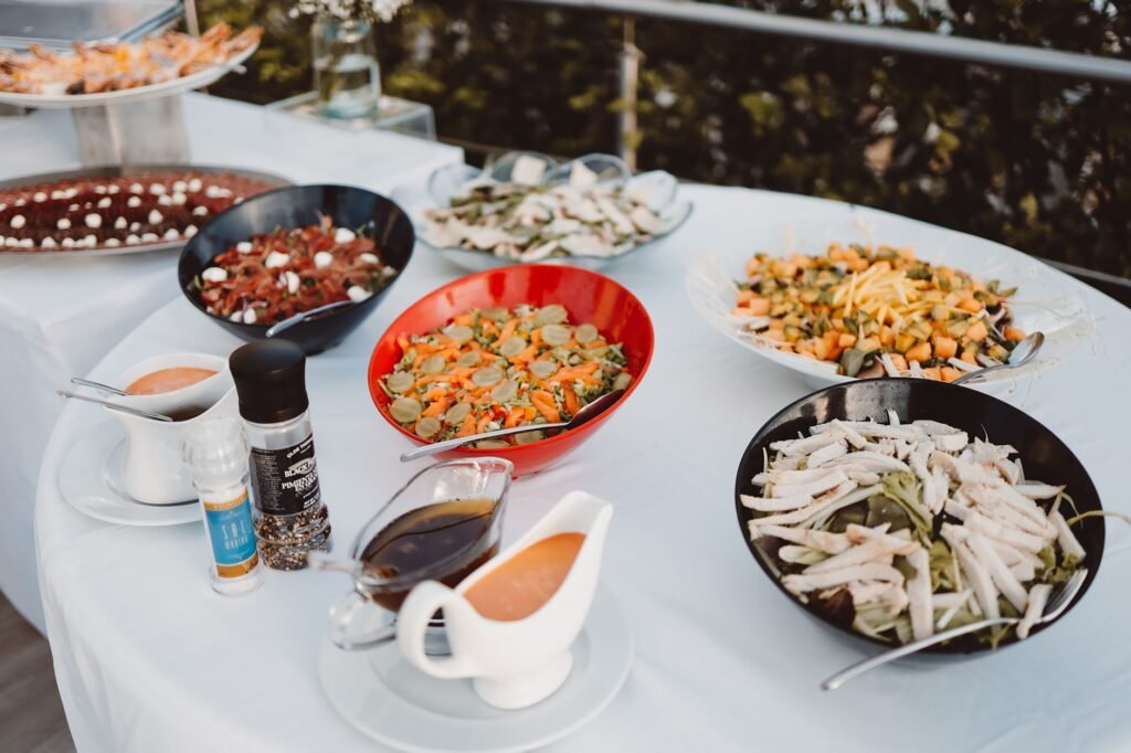 An enticing spread of salads and dressings on a buffet table, perfect for outdoor events.