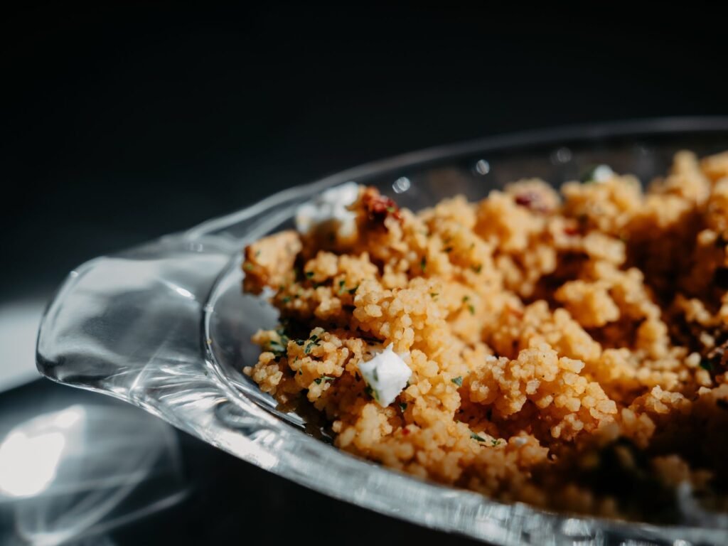 A close-up of homemade couscous served in a glass dish, perfect for dinner.