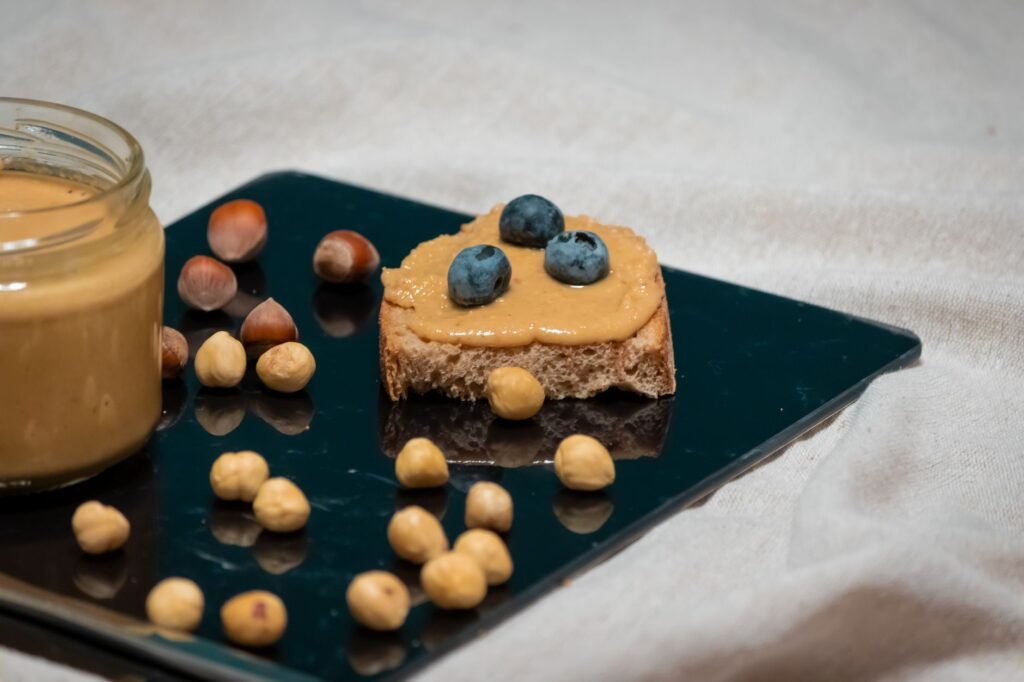 Delicious hazelnut spread with blueberries on a slice of bread, perfect for breakfast or snack.