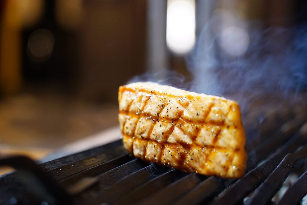 Delicious grilled salmon steak highlighted by smoky, flavorful grill marks. Perfect for culinary themes.
