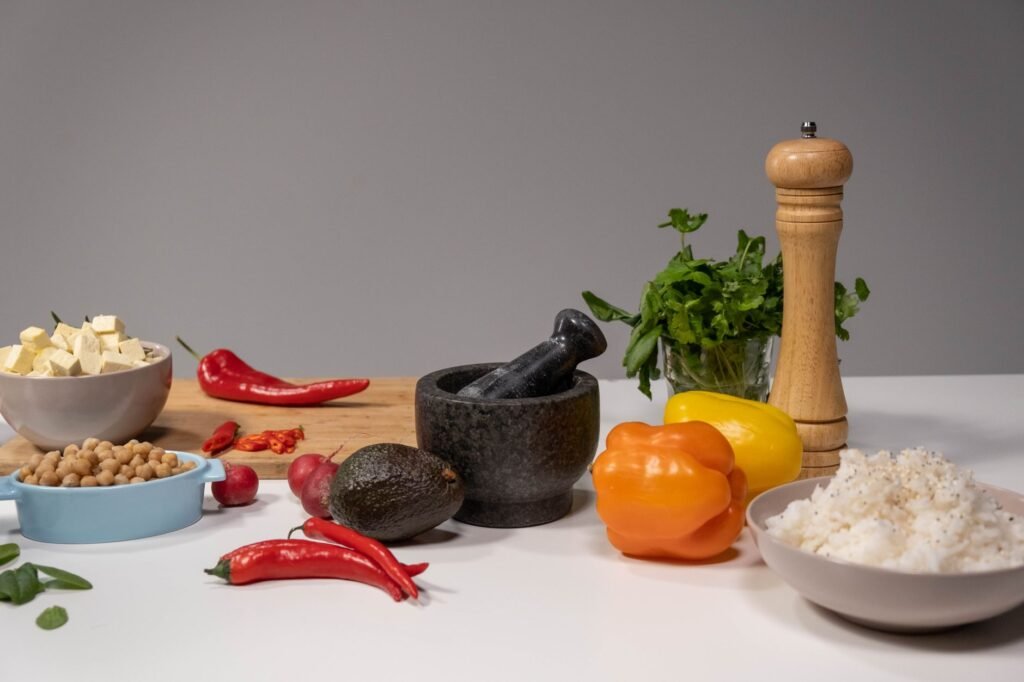 A vibrant assortment of fresh ingredients with a mortar and pestle setup for culinary preparation.