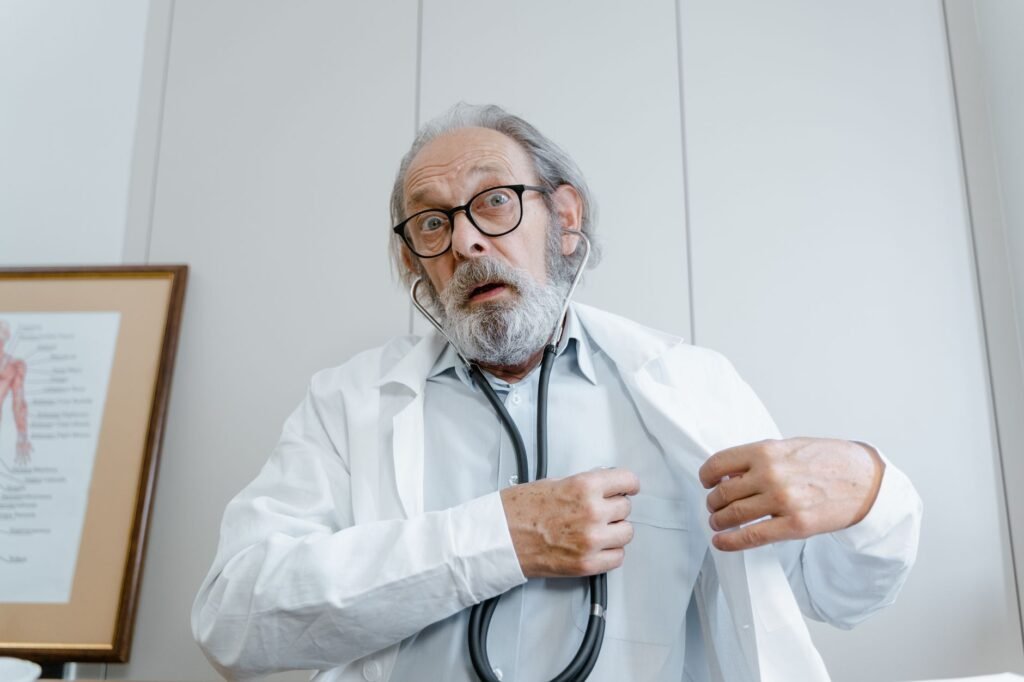 Surprised elderly doctor wearing lab coat and stethoscope indoors.